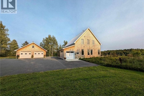 Two outbuildings, a two-bay garage and a single-bay garage with the house in the background. - 1059 Nb-365, Gauvreau