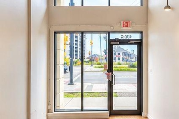 Interior view of commercial space entrance with glass doors and windows overlooking a street scene. - 105c - 370 Hwy 7 E, Richmond Hill