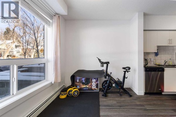 Another bedroom with carpet, open door to hallway, and simple furnishings - 106, 1740 9 Street Nw, Calgary
