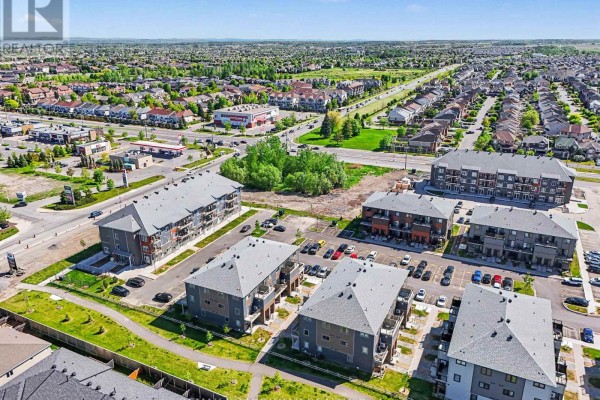 Aerial perspective of a modern commercial building complex with surrounding residential homes and a street. - 106 - 2370 Tenth Line Road, Ottawa