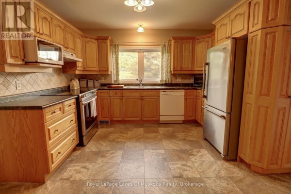 Another view of the kitchen showing light wood cabinets and checkered tile backsplash. - 106 - 31 Dairy Lane, Huntsville