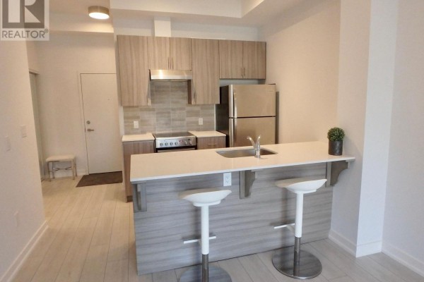 Modern kitchen with stainless appliances, island, light cabinets - 106 - 4040 Upper Middle Road, Burlington
