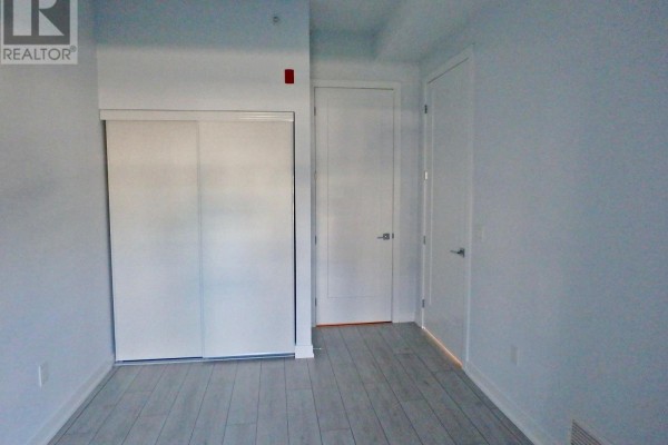 Bedroom with sliding closet doors, laminate floors - 106 - 4040 Upper Middle Road, Burlington