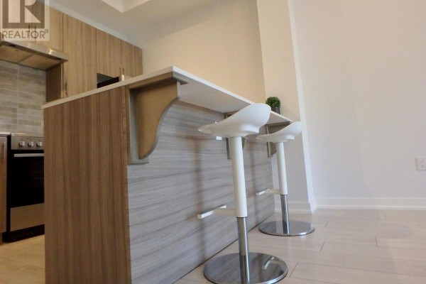 Modern kitchen with island, bar stools, and flat panel cabinets - 106 - 4040 Upper Middle Road, Burlington