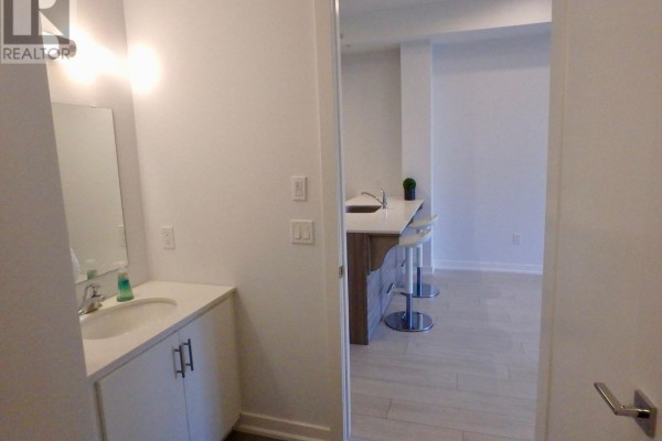 Modern kitchen with island, bar stools, and tile floors, plus bathroom vanity - 106 - 4040 Upper Middle Road, Burlington