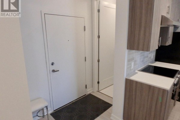 Modern entryway with white doors, kitchen cabinets, cooktop & tile backsplash - 106 - 4040 Upper Middle Road, Burlington