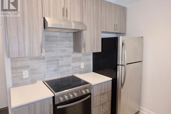 Kitchen with stainless appliances, wood-look cabinets, tile backsplash, white counters - 106 - 4040 Upper Middle Road, Burlington