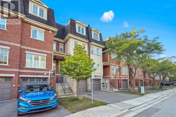 Street view of a townhouse complex showing the brick exterior, garages, and landscaping. - 106 - 435 Hensall Circle, Mississauga