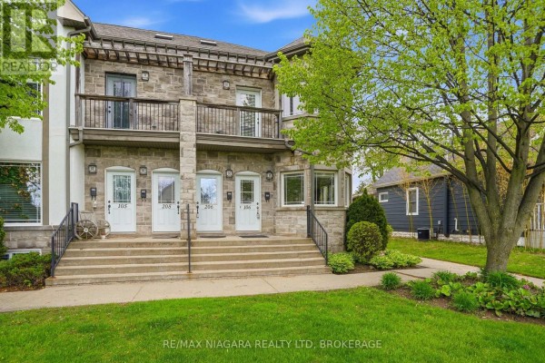 View of multiple townhouse units with stone exteriors and balconies. - 106 - 6045 Dunn Street, Niagara Falls
