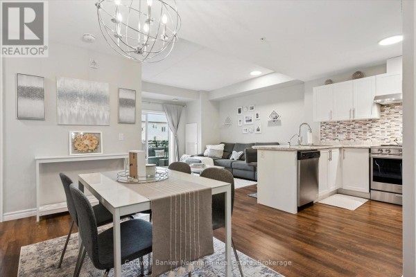 Living room with grey sectional sofa facing kitchen island with bar stools. - 106 - 7 Kay Crescent, Guelph