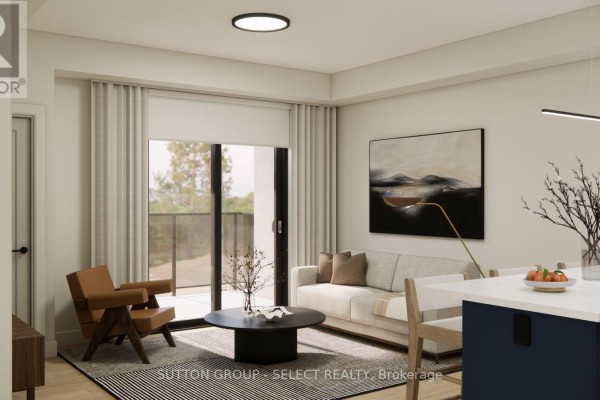 Living room with grey sofa, brown armchair, round coffee table, and large window. - 107 - 75 Suncoast Drive, Goderich)