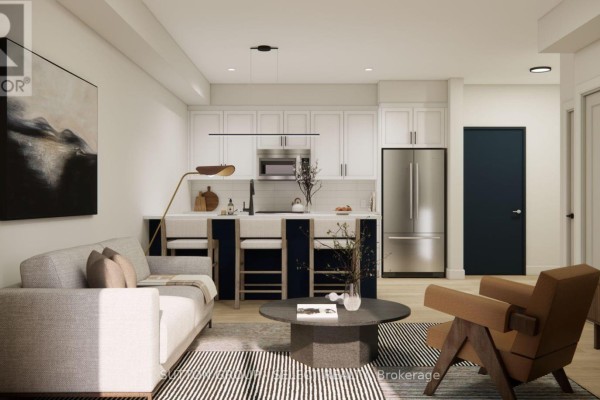 Open-concept living space with kitchen island, white cabinets, stainless steel appliances, and seating. - 107 - 75 Suncoast Drive, Goderich)