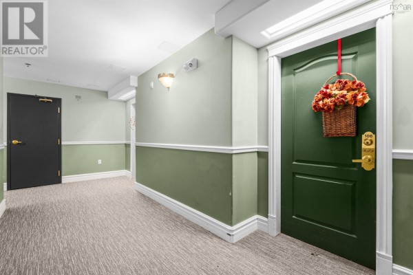 Interior apartment hallway with light green walls, white trim, and carpeted floor. - 106 - 78 Regency Park Drive, Clayton Park