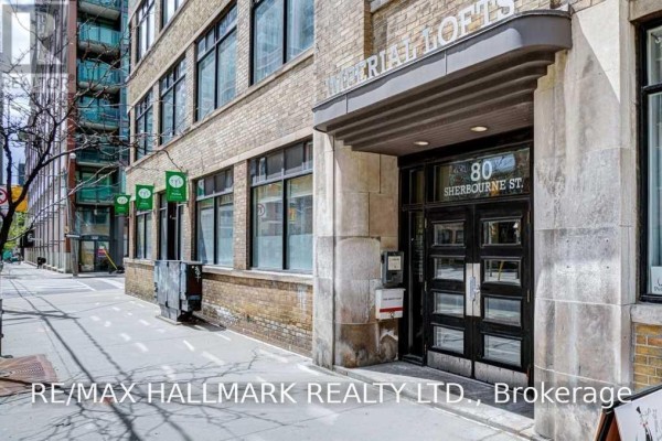 Entrance to a building with a large glass door and stone facade, with "80 SHERBOURNE ST." signage. - 106 - 80 Sherbourne Street, Toronto