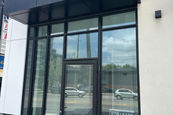 Large glass storefront windows with a black frame and a glass door. - 106 - 801 The Queensway, Toronto