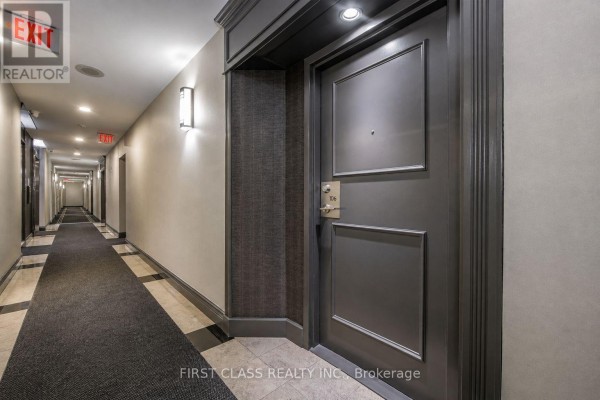 Long hallway with carpet and lighting, leading to apartment doors. - 106 - 91 Townsgate Drive, Vaughan