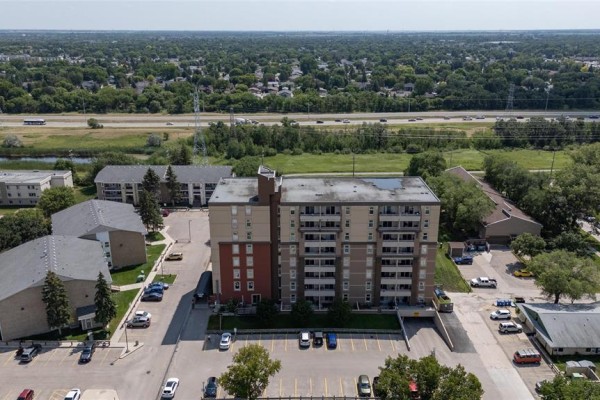 High aerial view of the apartment building, showing its location within a suburban landscape. - 106 180 Beliveau Road, Winnipeg
