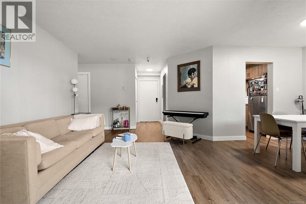 Living and dining area with neutral color palette, fireplace, and sliding door access. - 106 71 Gorge Rd W, Saanich