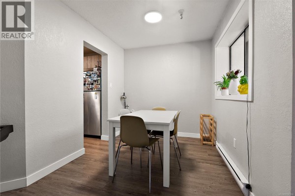 Living room featuring a beige sofa, gas fireplace, and a piano in the foreground. - 106 71 Gorge Rd W, Saanich