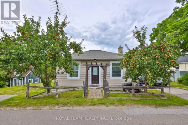 Front view of a beige house with a wooden pergola over the entrance and two apple trees. - 106 Centre Street, King