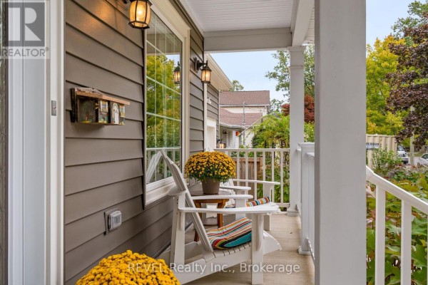 Close-up of a covered front porch with two white Adirondack chairs and a small table. - 106 Dalhousie Avenue, St  Catharines