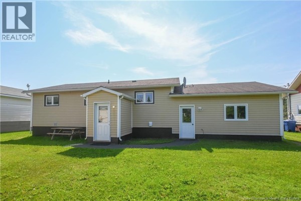 Kitchen with white cabinets, stainless steel appliances, and an island with seating. - 106 Des Champs Street, Lameque