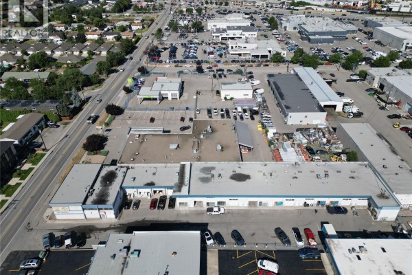 Aerial view of commercial area with multiple buildings and parking lots, showcasing nearby amenities. - 1060 Leathead Road Unit# 8a, Kelowna