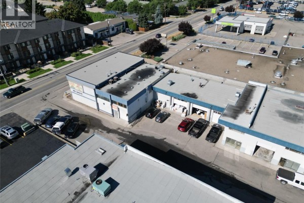 Aerial view of commercial units with parking spaces, highlighting the layout and surrounding roads. - 1060 Leathead Road Unit# 8a, Kelowna