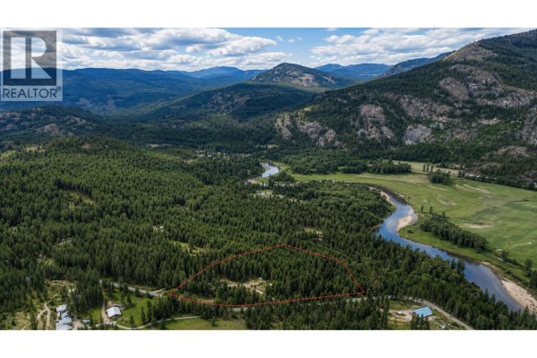 Panoramic aerial view of a vast, wooded lot outlined in red, with a river and valley in the background. - 10625 Granby Road Lot# 1, Grand Forks
