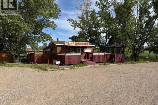 Outdoor seating area with snow-covered picnic tables and benches under a covered gazebo. - 10627 20 Highway, Lumsden Rm No  189