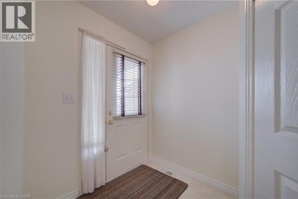 Interior entryway with a white door, window with blinds, and a brown patterned rug. - 1064 Copper Leaf Crescent, Kitchener
