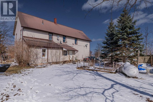 Rear exterior of a light beige home with a metal roof and a snowy backyard. - 1064 Prince Street, Lansdowne Village