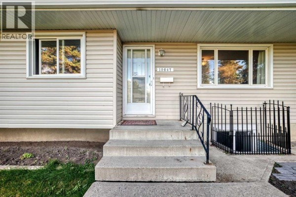 Close-up of the home's entrance with concrete steps, railing, and front door. - 10647 Shillington Crescent Sw, Calgary
