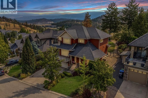 Aerial view of the residential property on a sunny day with a distant mountain view. - 1065 Long Ridge Drive, Kelowna