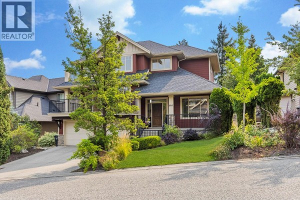 Side view of the house with a driveway and mature trees. - 1065 Long Ridge Drive, Kelowna