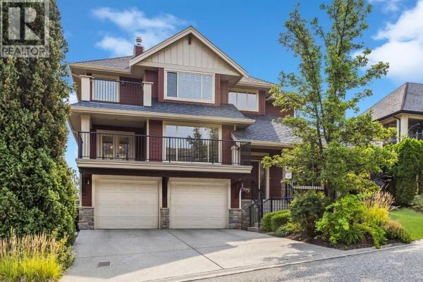 Front view of the house showing a triple-car garage and balconies. - 1065 Long Ridge Drive, Kelowna