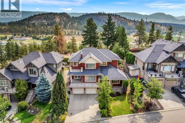 Aerial view of the neighborhood showcasing multiple houses and natural landscape. - 1065 Long Ridge Drive, Kelowna
