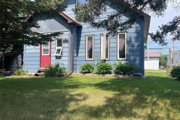 Front entrance of blue siding house with red door and white trim. - 1067 St. Clare Street, Birtle