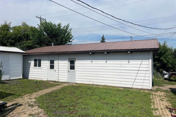 White detached garage with two doors and a brown metal roof. - 1067 St. Clare Street, Birtle