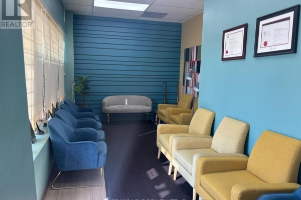 Waiting area with blue and yellow chairs and teal walls. - 107 - 1339 Khalsa Drive, Mississauga
