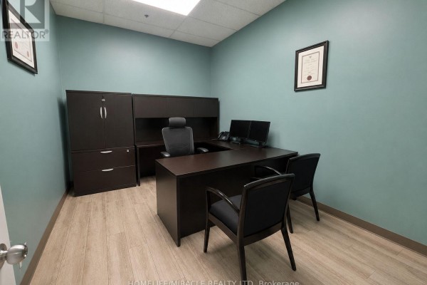 Office with a U-shaped desk, computers, chairs, and dark storage cabinets. - 107 - 1339 Khalsa Drive, Mississauga