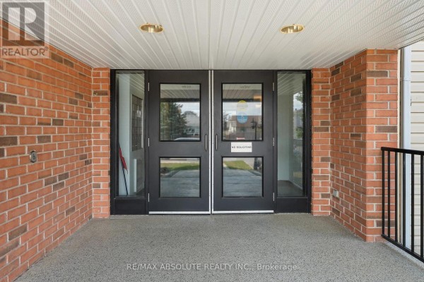 Building entrance with double glass doors, brick facade, and security intercoms. - 107 - 16 Sheffield Street, Arnprior