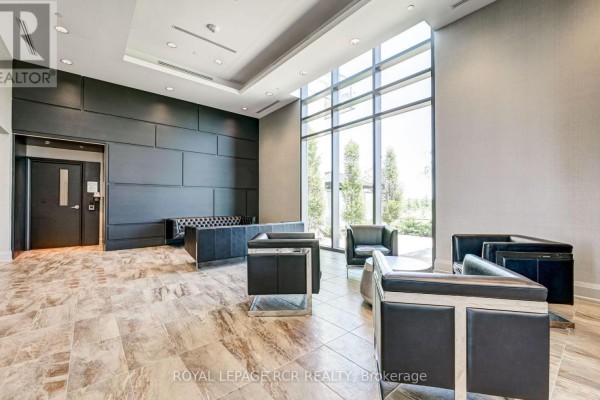 Apartment building gym with cardio machines, weight machines, and large windows. - 107 - 65 Yorkland Boulevard, Brampton