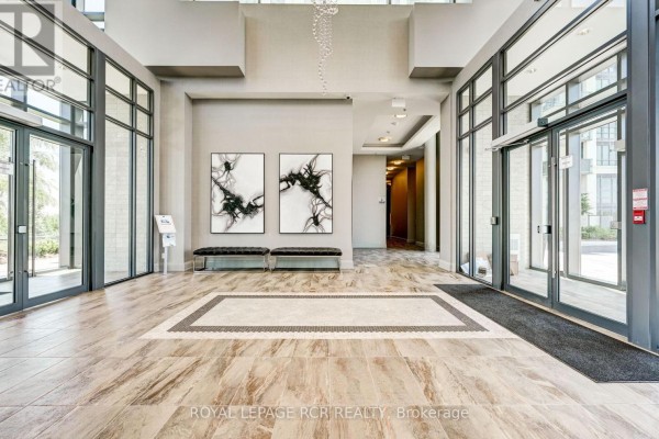 Apartment patio with seating area and glass doors leading indoors. - 107 - 65 Yorkland Boulevard, Brampton