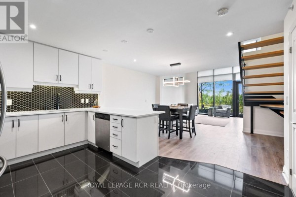 Community room with dining table, chairs, and a full-service kitchen. - 107 - 65 Yorkland Boulevard, Brampton