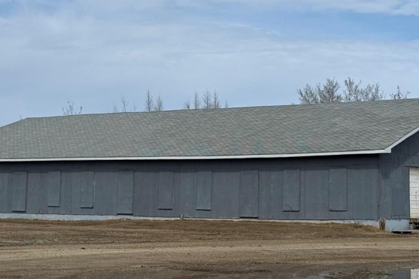 Close-up of the Home Hardware entrance with glass doors and signs on the windows. - 107 & 116 Brown Street, La Ronge
