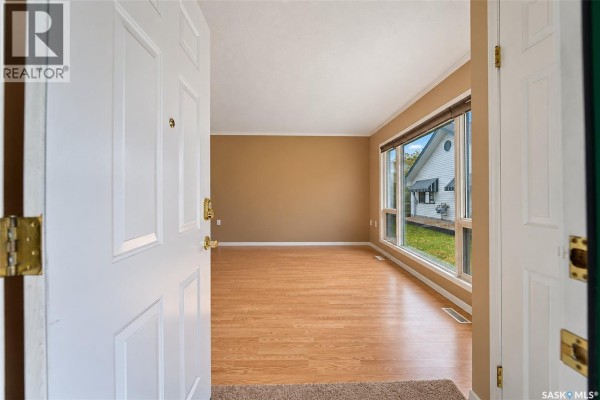 View from inside the entrance looking into an empty living room with large windows. - 107 111 2nd Avenue E, Rosetown