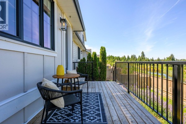 Dining area with a round table, chairs, and wall art. - 107 4098 Buckstone Rd, Courtenay