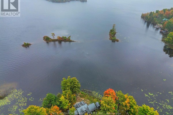 Aerial view of the house and surrounding islands on a wide, calm lake with colorful trees. - 107 Beck Shore Road, Drummond/north Elmsley
