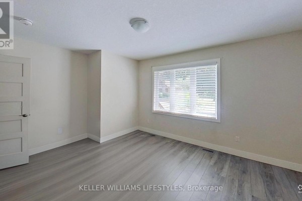 Bedroom with modern gray flooring, interior door, and window - 107 Cavendish Crescent London North